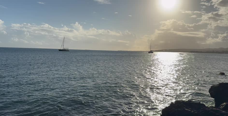 Cinematic 4K wide shot of the tropical Caribbean coastline in Puerto Rico, featuring the blue ocean horizon, rocky shores, and scenic coastal views under a clear bright sky.