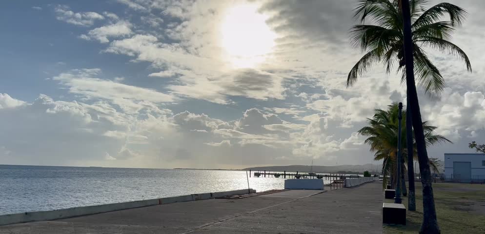 Cinematic 4K wide shot of the tropical Caribbean coastline in Puerto Rico, featuring the blue ocean horizon, rocky shores, and scenic coastal views under a clear bright sky.