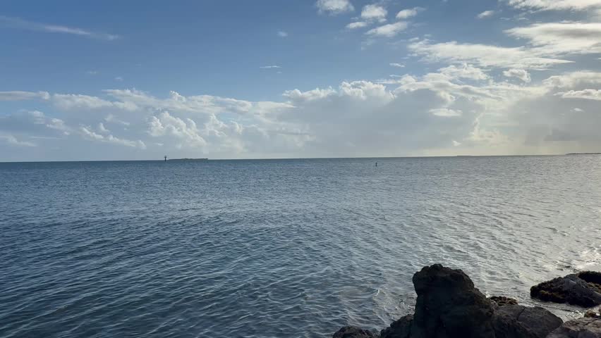 Cinematic 4K wide shot of the tropical Caribbean coastline in Puerto Rico, featuring the blue ocean horizon, rocky shores, and scenic coastal views under a clear bright sky.