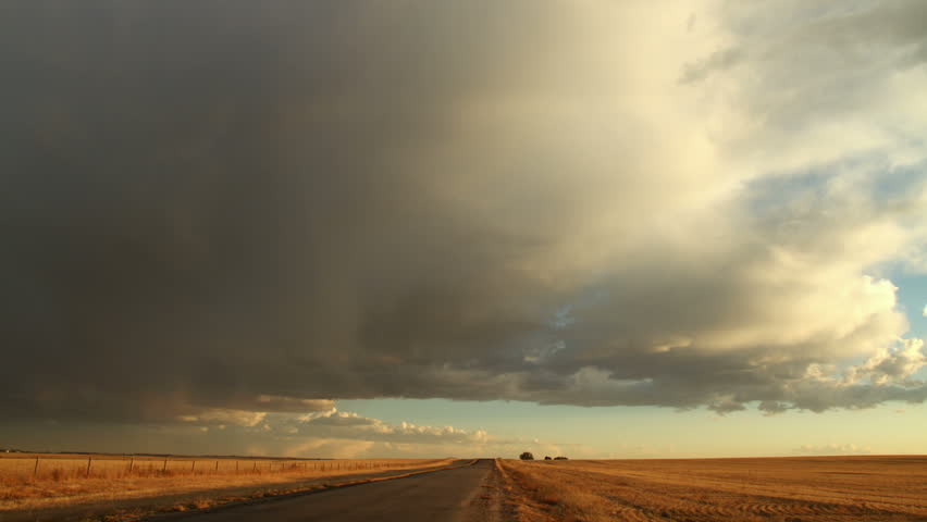 Storm Clouds over Rural Dirt Road and Meadow. HD 1080p timelapse