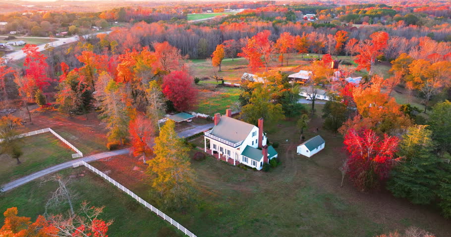Big countryside homes among colorful autumn woods with yellow leaves reflecting seasonal charm and rustic comfort of southern USA states.