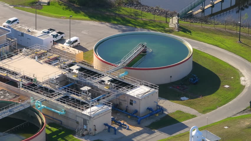 Large-scale industrial water treatment plant purifying and recycling water through filtration and chemical processes to meet health and safety standards.