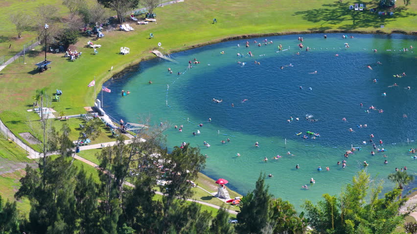 Scenic geothermal spring surrounded by nature, featuring saline water, swimmers floating peacefully, and a tranquil atmosphere connected to relaxation and healthy lifestyle.