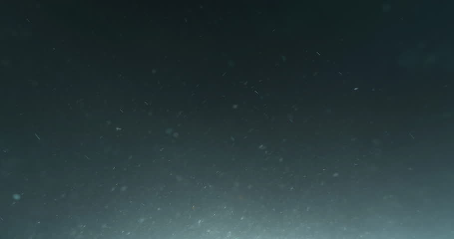 Cinematic 4K underwater footage captured from the POV of a deep-sea ROV drone, drifting through a vast, atmospheric water column filled with floating particles, soft light rays, and immersive depth—pe