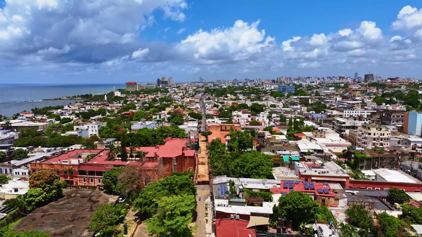 Picturesque aerial view of a city street with historical landmarks. Santo Domingo, the capital of the Dominican Republic, on a sunny summer day. Cultural monuments of Latin America. Red roofs of the old town.