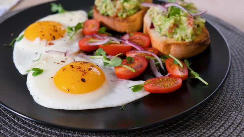Spinning brunch plate with sunny side up eggs and avocado toast