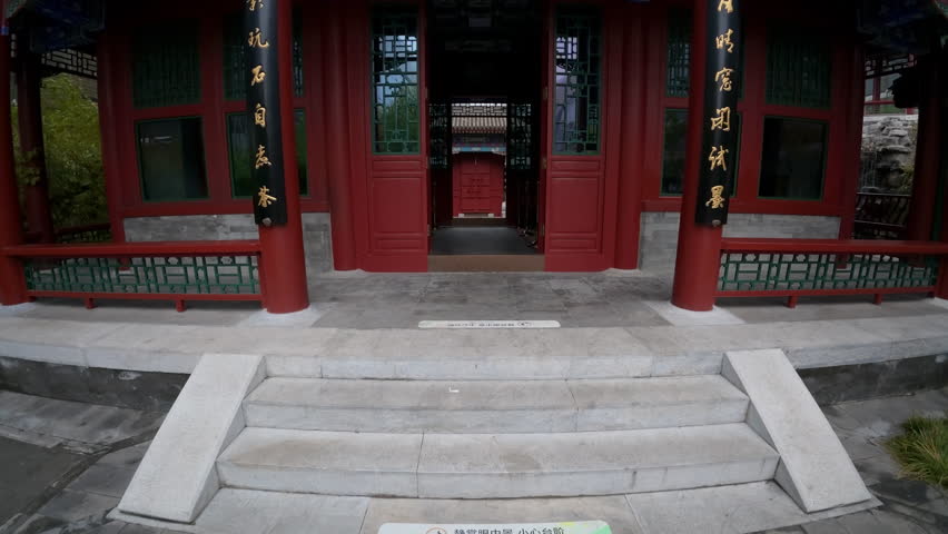 Tilting shot revealing the colorful and intricate architecture of a traditional Chinese Pavilion