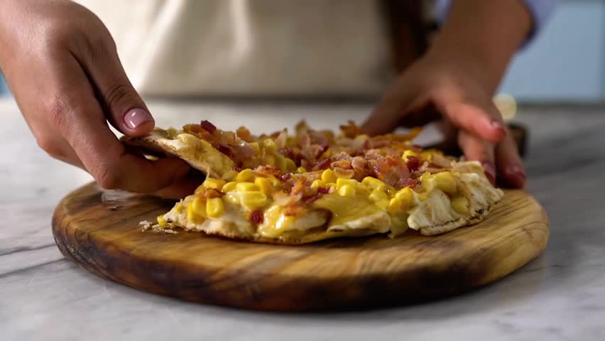 Close up a hand taking a slice pizza. hands of male taking pizza slices at table, taking slice of pizza with super stretching stretchy cheese