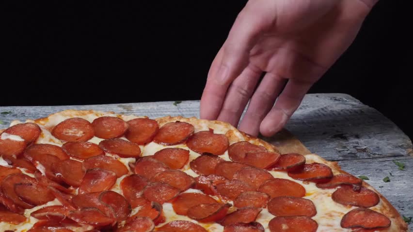 taking pizza slice from the table. Tasty fast food Hand taking pizza slice. Woman picking up slice of pizza. delicious food with different ingredients.