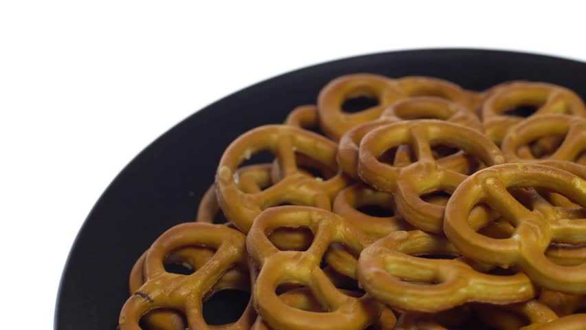 Delicious pretzels cookies on a black plate with white background. Closeup shot of Crusty Knot Shaped Pretzel Cookies on White isolated Background.