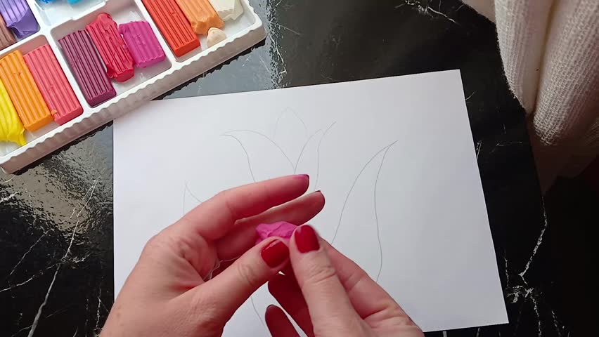 Stock video: drawing with plasticine on paper, a woman