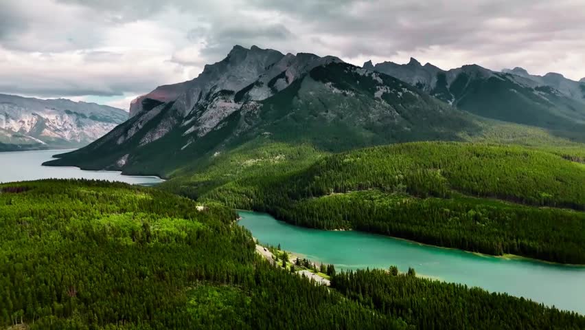 Aerial landscape of vast forest and towering mountains under overcast sky, showcasing raw wilderness, natural environment and dramatic geography, serene adventure scenery, 07 April 2026
