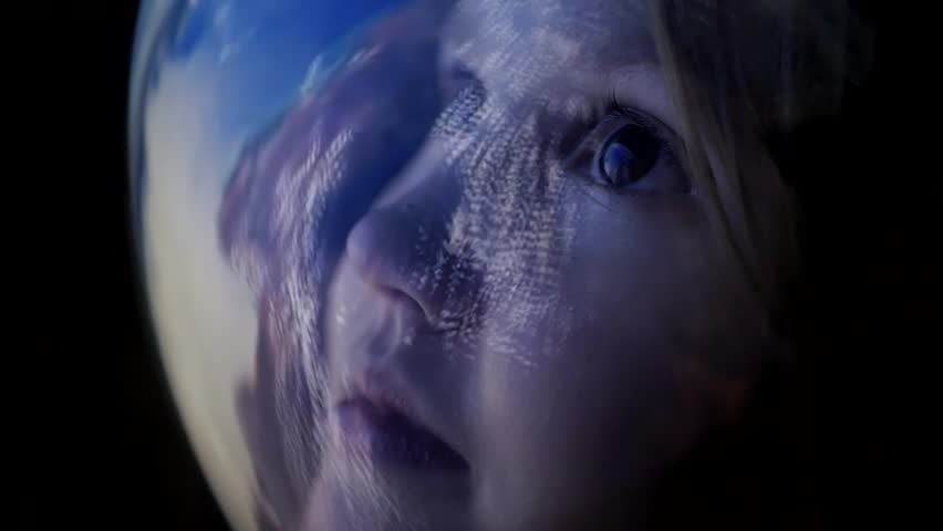 Cute child in astronaut helmet watching with wonder and admiration a planet from space Girl in spacesuit looking through glass at view of space and Earth. Discovery of new horizons. Flight to the Moon