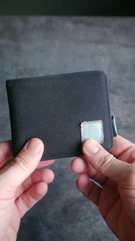 Male hands opening black wallet and showing it is empty, concept representing poverty, lack of money, unemployment, bankruptcy, financial crisis, and economic recession. Vertical