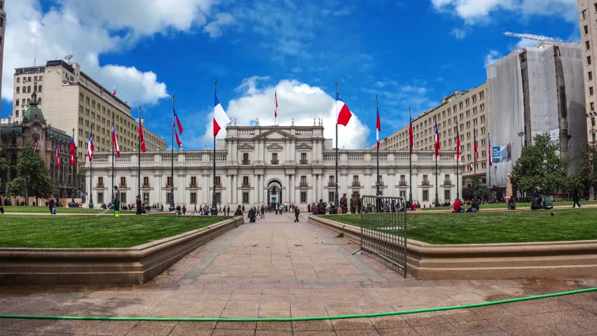 People walking in front of the Palacio de La Moneda (Palace of the Mint), the seat of the President of the Republic of Chile the offices of three cabinet ministers.
Santiago, Chile An outdoor view of the La Moneda Palace in Santiago, Chile