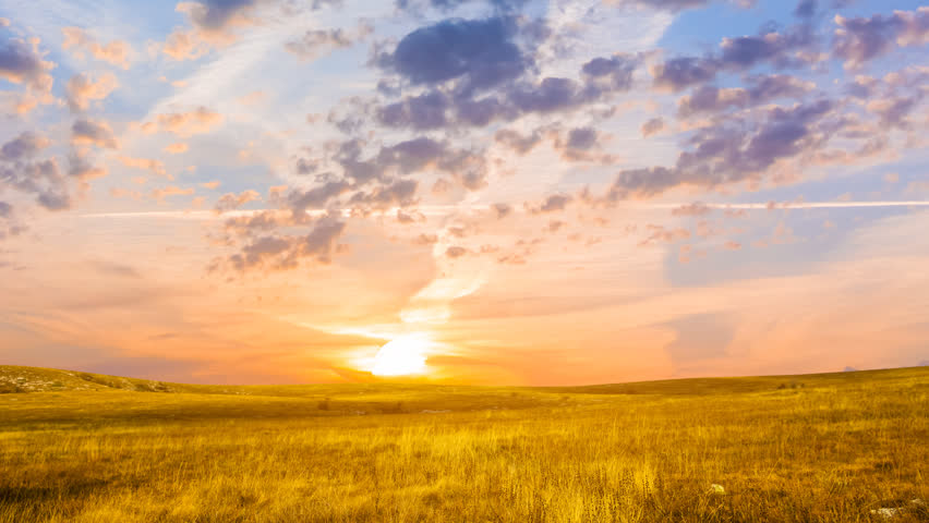 dramatic sunset over the grass prairie time lapse scene