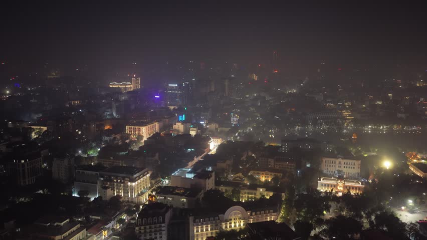Aerial panorama of Hanoi, Vietnam illuminating the city downtown skyline and bustling urban streets with traffic during night