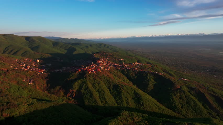 Aerial drone view of Sighnaghi, Georgia, showcasing the hilltop town, surrounding landscape, and charming architecture from above in clear daylight.