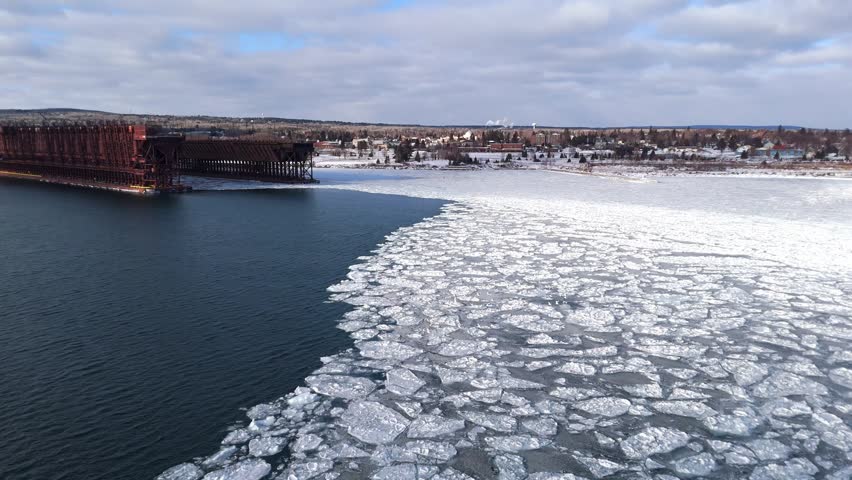 Flock of seagull flying over Lake Superior on a winter sunset with ice formations on lake surface, Two Harbors Minnesota