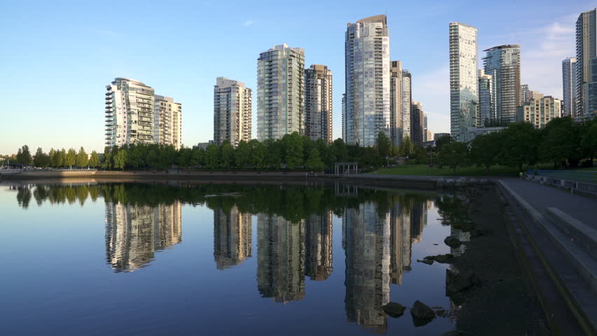 Quiet Sunrise Reflection False Creek Vancouver 4K UHD. Yaletown towers across the False Creek shoreline at sunrise in Vancouver. British Columbia, Canada. 4K, UHD.

