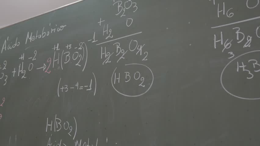 Blackboard filled with chemistry formulas. Handwritten equations show boron oxide reactions. Text includes H2O, H3BO3, and H2B4O7. Ideal for educational clips or science-themed projects