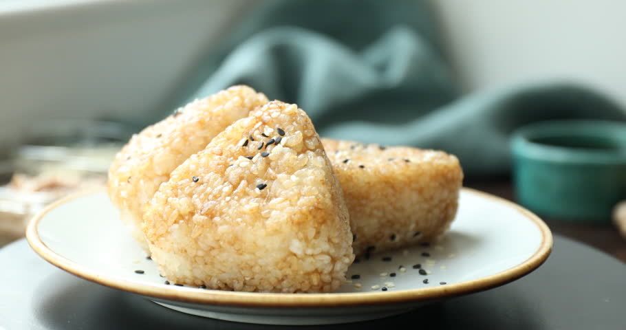 Delicious Yaki Onigiri (grilled rice balls) on table, rotating