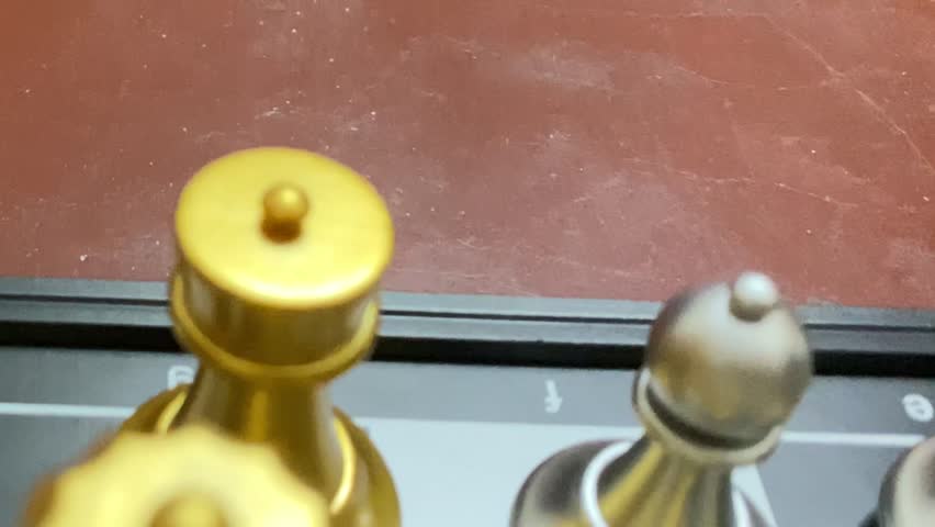 Strategic chess game with golden and silver pieces on chess board - close up shot.