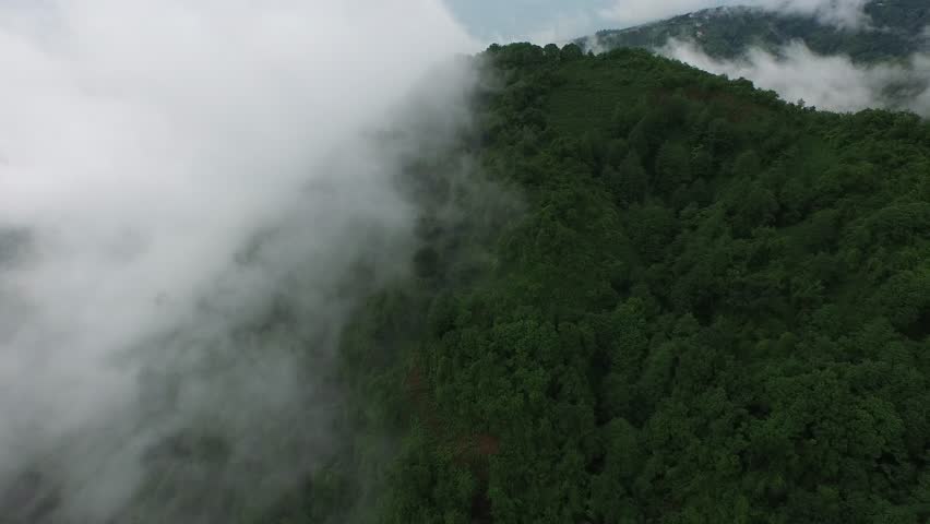 Aerial village houses in scattered settlements in clouds over rainforest in Black Sea Turkey. Mist drifts above green hills remote villages and lush mountain scenery amid rugged highlands. Turkey, Village, and Houses present place identity, structure detail, and strong architectural context. The scene works well for tourism, heritage, landmark, and destination related searches. Recognizable location features make the clip useful for travel promotion and documentary storytelling.