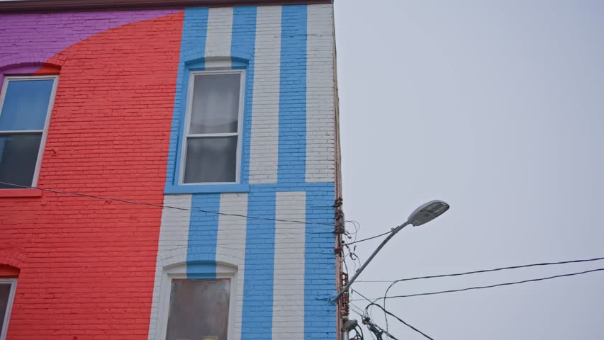 Cinematic right to left pan across colorful building in downtown Jackson Michigan highlighting architecture and urban street scene.