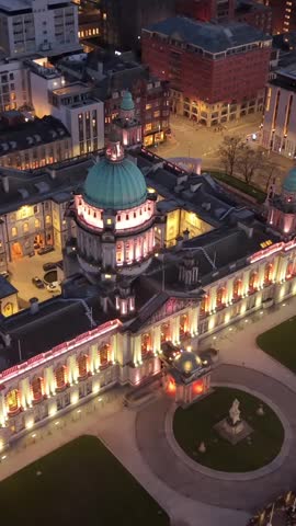 Anti-clockwise 4K 60FPS aerial GV of Belfast City Hall in Belfast City Centre, Northern Ireland at night. Produced with Rec709 color.