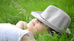 Kid lying on green summer grass enjoying and relaxing on nice wind