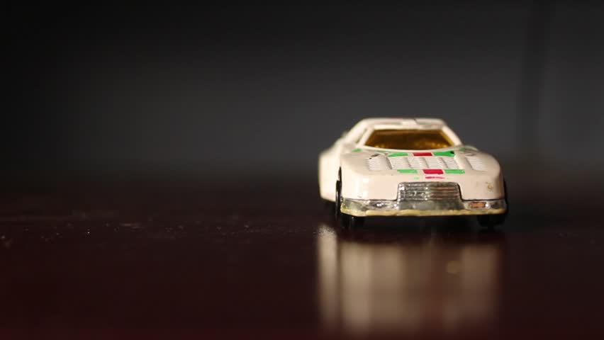 A yellow toy car hitting a white toy car as a bunch of steam comes out of the engines