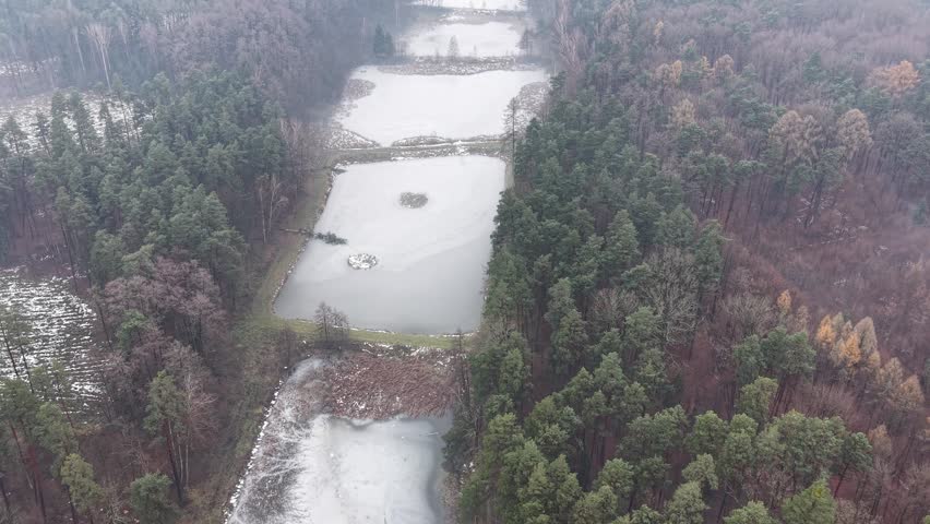 Aerial perspective of water reservoirs in winter woods