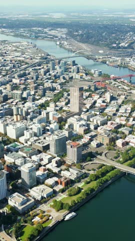 Aerial view of Portland city skyline moving over Willamette river bridges and downtown skyscrapers.