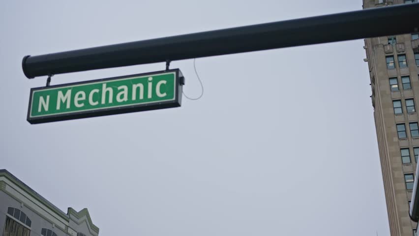 Cinematic tilt down from North Mechanic Street sign revealing downtown Jackson Michigan street and urban environment.
