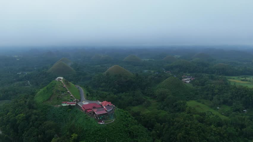 An aerial flyover passes over Chocolate Hills Complex and surrounding limestone hills in Bohol