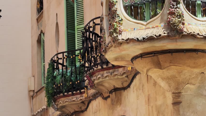 An establishing shot of a classic Gaudi style building balcony in Palma de Mallorca, Spain. Showcases authentic historic architecture.