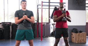 Holding chest-level dumbbells, training partners performing goblet squats in gym for strength. Fitness, strength, training, gym, workout, athletic, competition - Powered by Shutterstock - Get 15% off with code: PIKWIZARD15