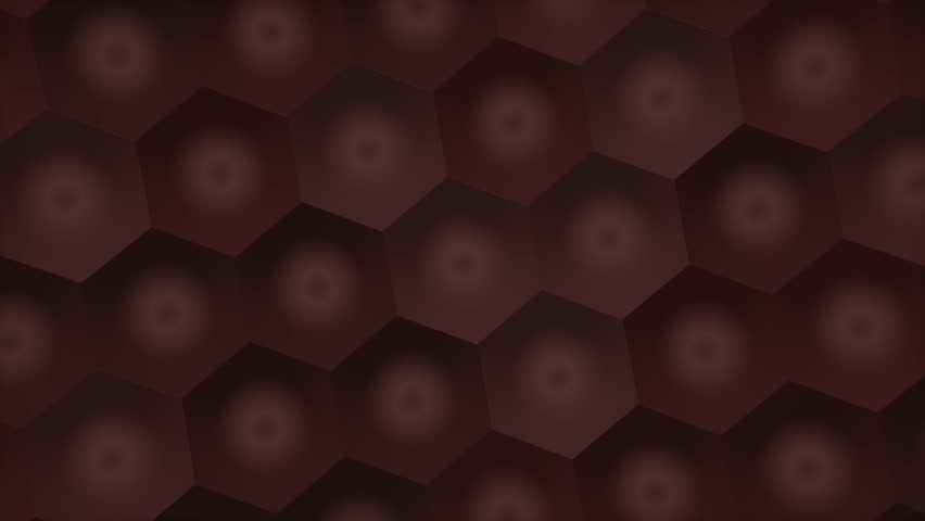 A close view of a geometric hexagonal pattern with soft red tones and gentle shading, creating a shallow depth effect in a muted, low light setting.