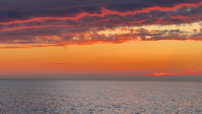 Scenic sunset over sea and shoreline with glowing sky