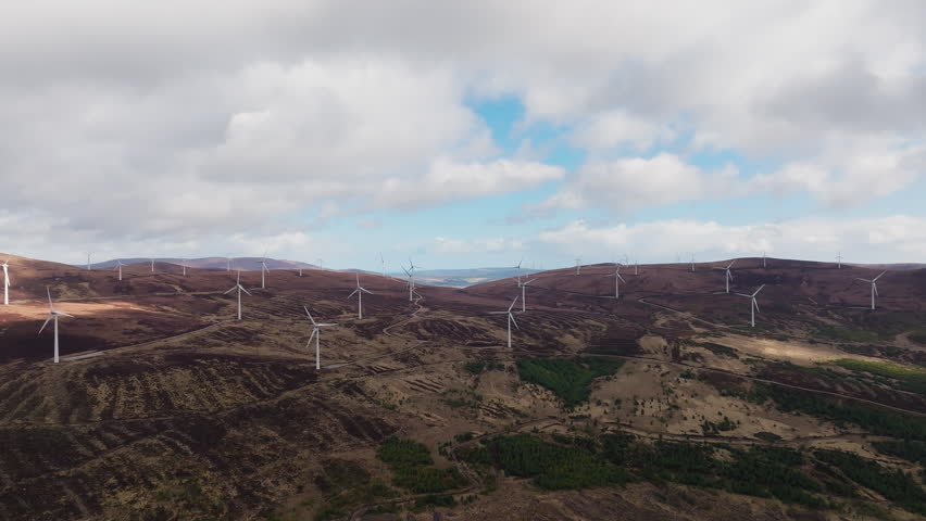 Wind turbines near the pink house at Loch Glass in Scottish Highlands, Scotland, Aerial panoramic view