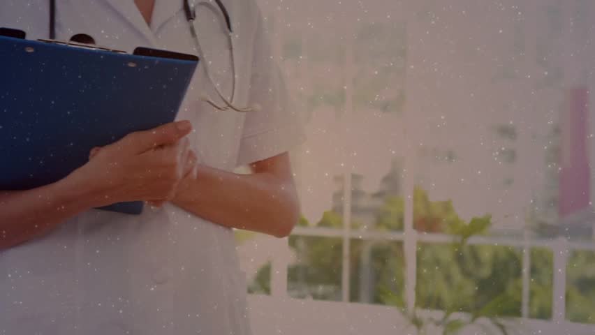 Medical staff holding dark tablet and stethoscopes, male pointing, icons floating in clinic window. Collaboration, colleagues, screen, notifications, analytics, sunlit, greenery