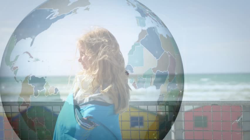 Two girls laughing by railing second entering from left engaging with floating globe for education. Coastal, boardwalk, ocean, sunshine, friendship, laughter, bubble