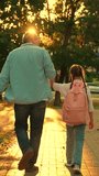 Father accompanies child girl with backpack home from school on city street. Dad young daughter walk school together. Happy family. Parenting concept father child. Family city park. Educating people - Powered by Shutterstock - Get 15% off with code: PIKWIZARD15