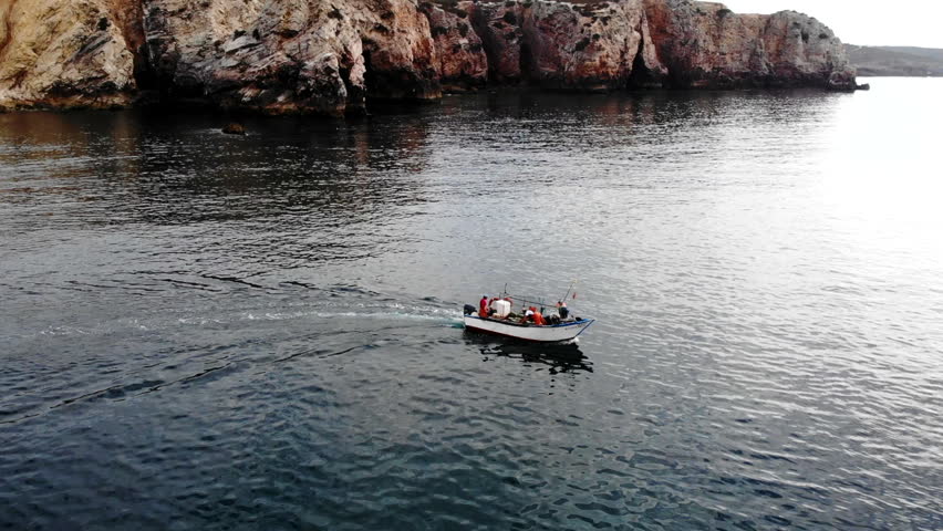 Small Patrol Vessel Navigating Near Cliffs With Crew Ensuring Maritime Safety And Rescue Efficiency . Media