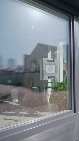 Window cleaning robot moves on glass with cable hanging below. Concept of cleaning technology