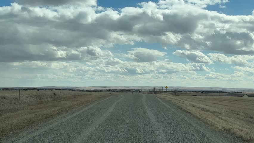 POV Journey Along Gravel Road Through Alberta Countryside In Early Spring With Natural Prairie Setting