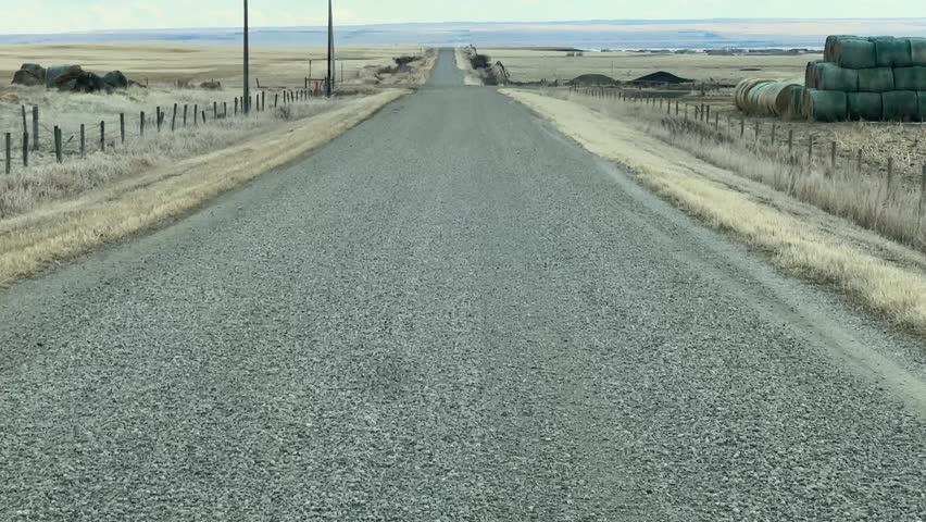 Gravel Road in Early Spring Alberta Countryside with Open Prairie Landscape and Natural Scenery