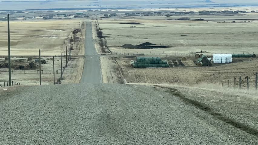 Driving Down Rural Gravel Road in Early Spring Alberta Countryside with Open Prairie Landscape and Natural Scenery