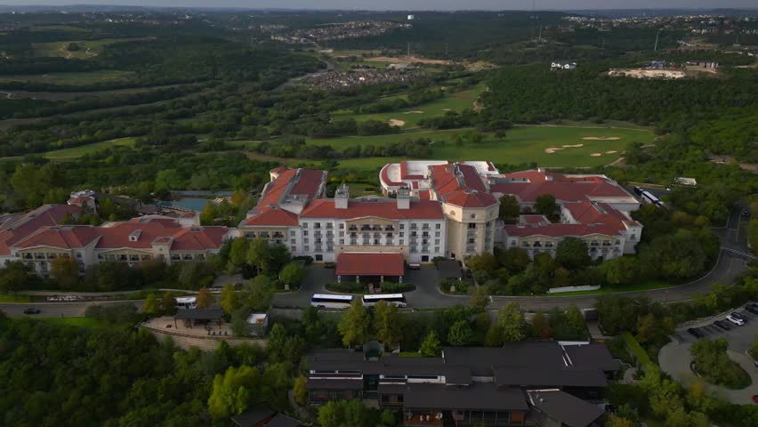 Aerial drone footage captures a large resort and adjacent golf course surrounded by greenery in San Antonio, Texas. Ideal for tourism or real estate promotion. 10.7 seconds, 3840x2160 resolution. S...